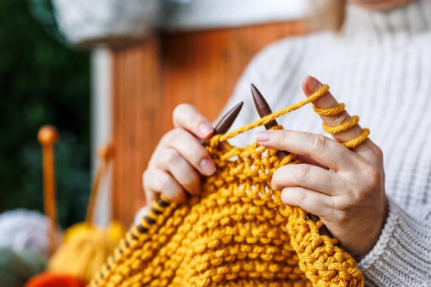 Hands knitting with wool yarn, beginner crochet guide